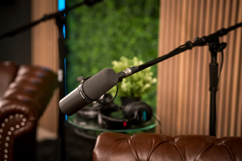 A studio microphone between the leather armchairs on the couch set