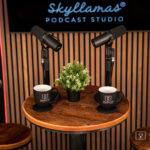 professional podcast recoridng mics on a table and skyllamas mugs